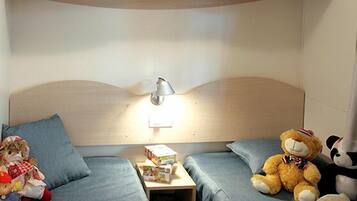 Cozy retreat with a single bed, table, and plush couch.