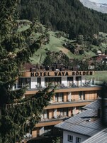 Un hotel de diseño moderno, con varios balcones y vistas a un paisaje montañoso.