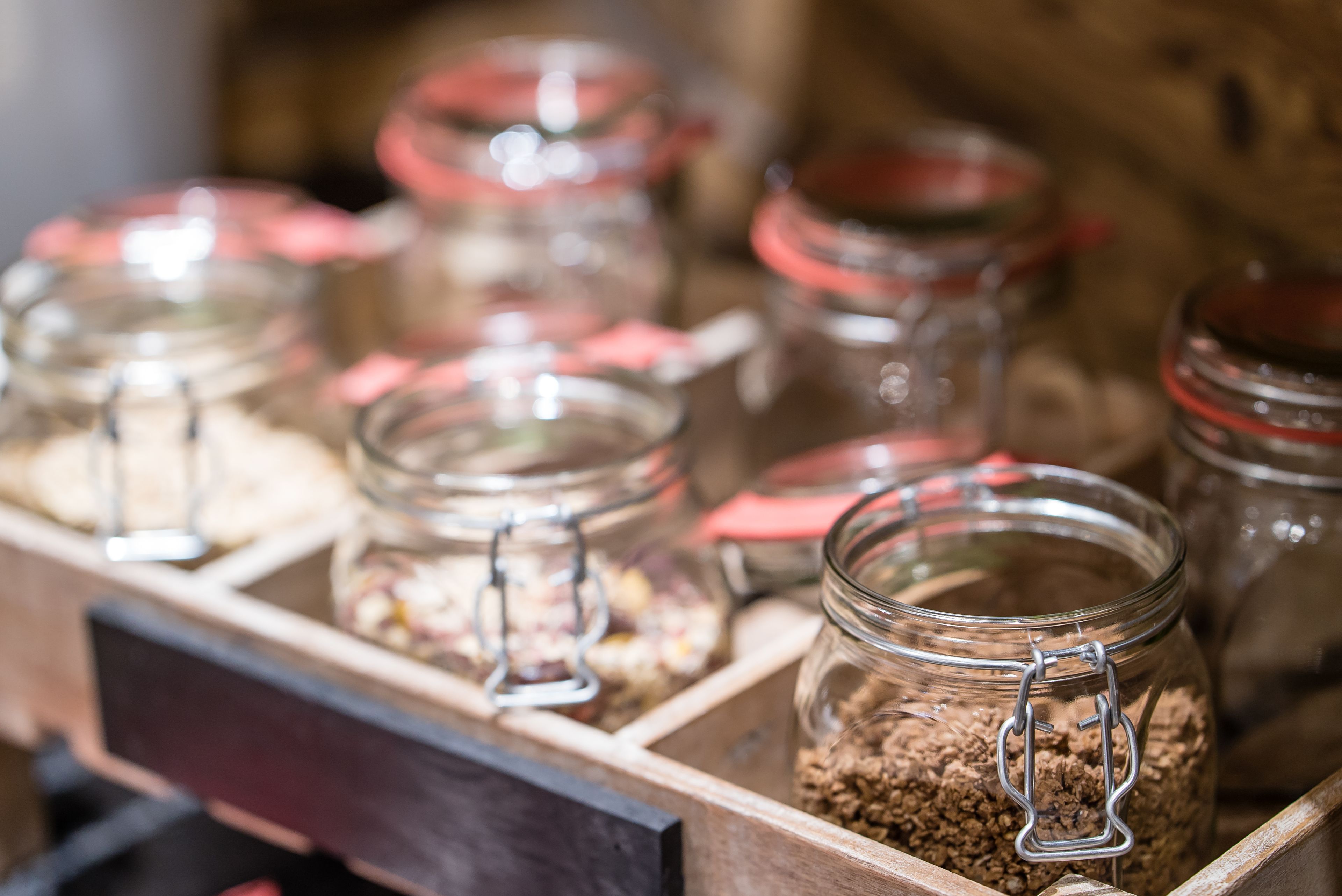 Una vitrina de madera con varios frascos de vidrio que contienen distintos alimentos.