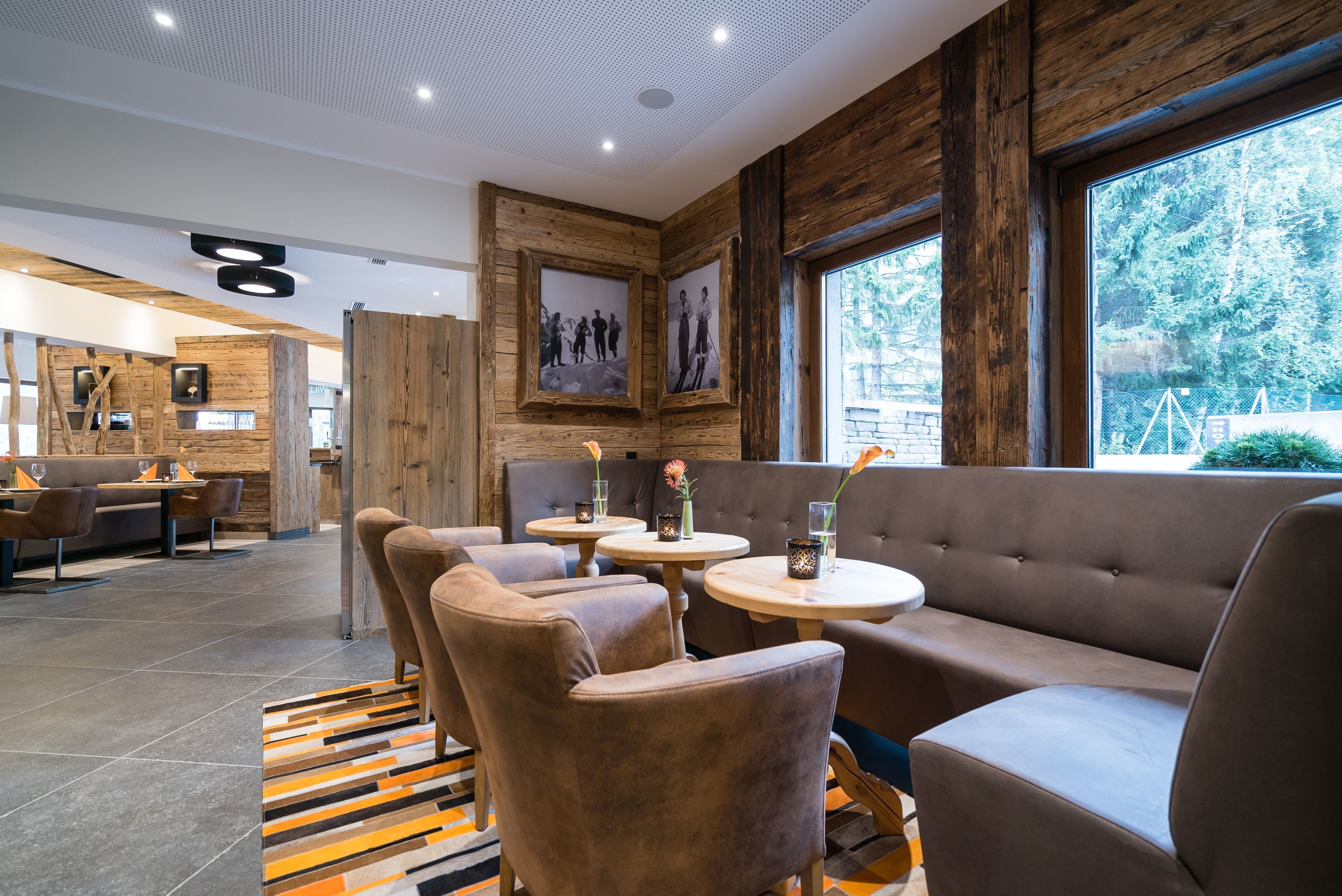 A modern interior with wooden accents, seating areas, and framed pictures on the walls.