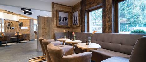 A modern interior with wooden accents, seating areas, and framed pictures on the walls.