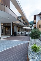 Un edificio moderno con un restaurante llamado "Vaya Bar & Grill" que cuenta con terraza y una cubierta de madera.