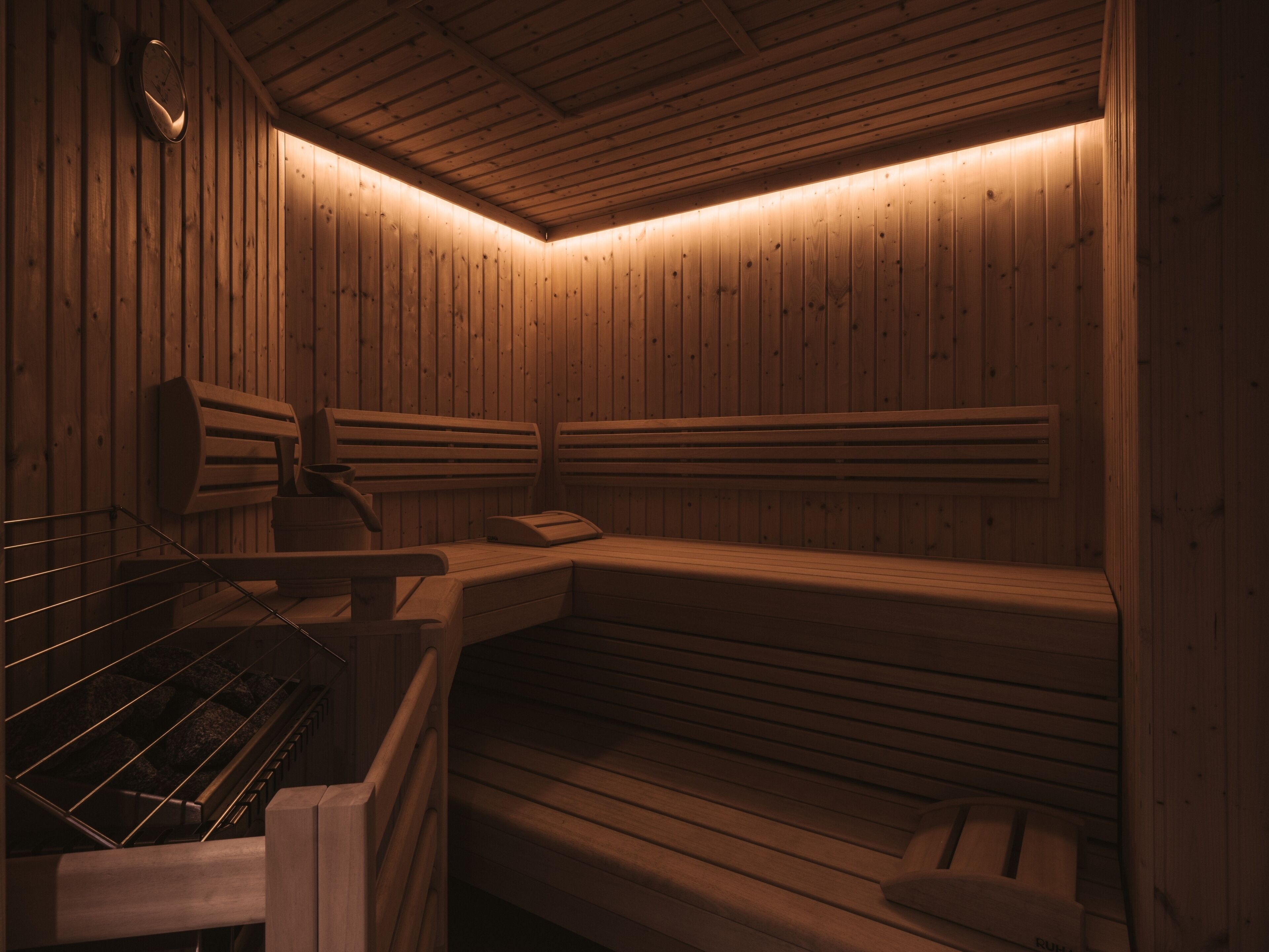 Un sauna avec des bancs en bois et un banc muni d’une serviette.