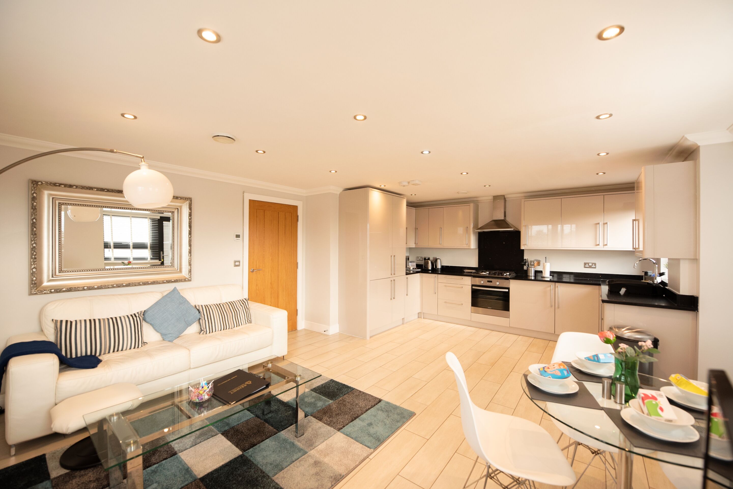 A modern living room with a sofa, coffee table, and dining area.
