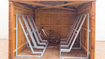 A wooden structure with metal bike racks and a bicycle inside.