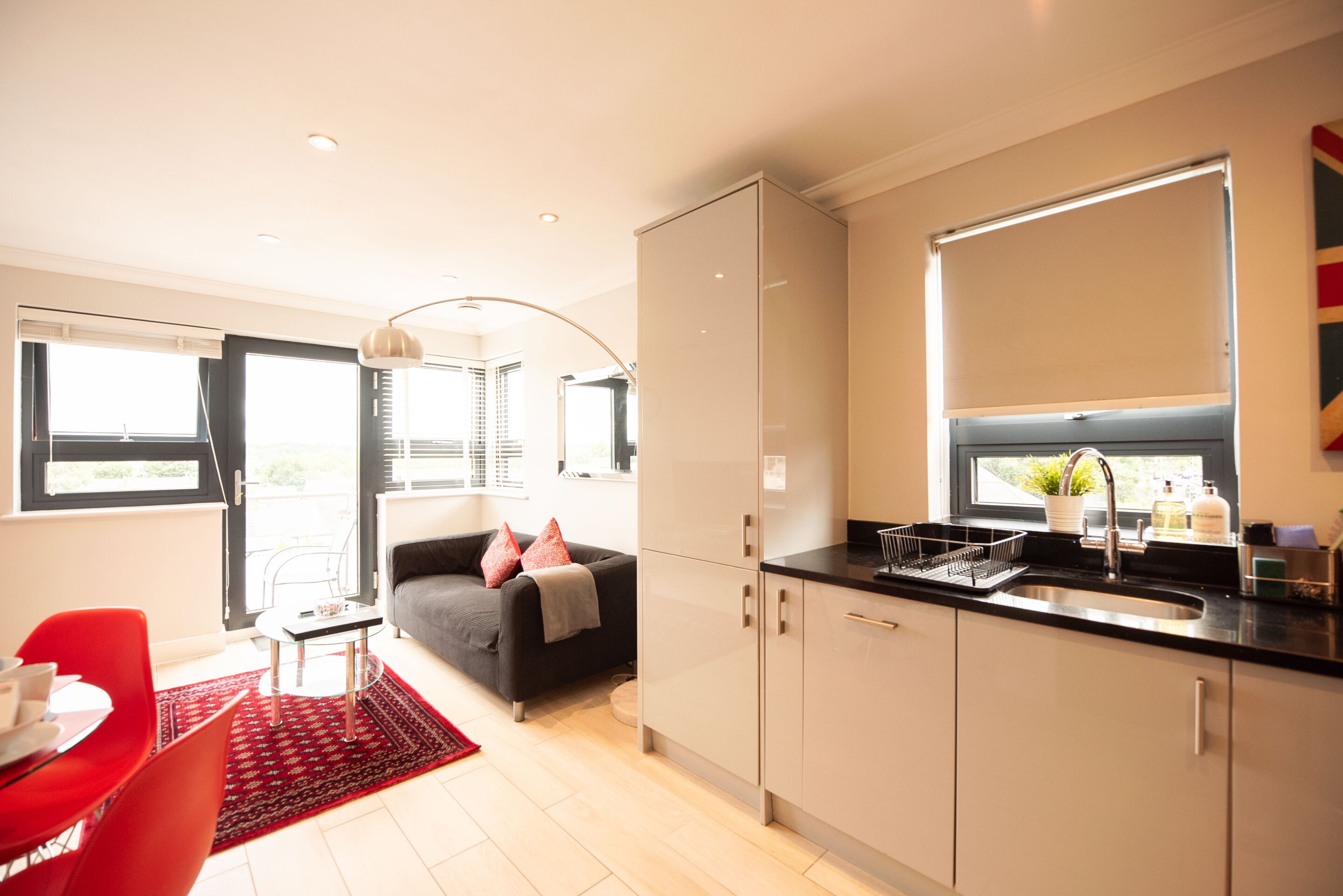 A modern kitchen with a black countertop, a built-in oven, and a window above the sink.