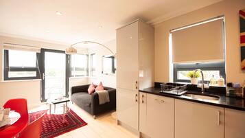 A modern kitchen with a black countertop, a built-in oven, and a window above the sink.