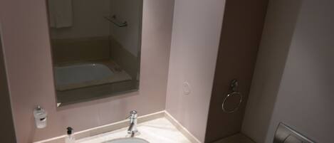 A bathroom with a sink, mirror, and a towel rack.