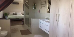 A bedroom with a bed, a bedside table, and a window.