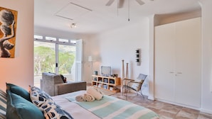 Un dormitorio con cama, televisor, estantería y armario.