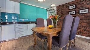 Un coin repas avec une table en bois, quatre chaises et un vase de fleurs.