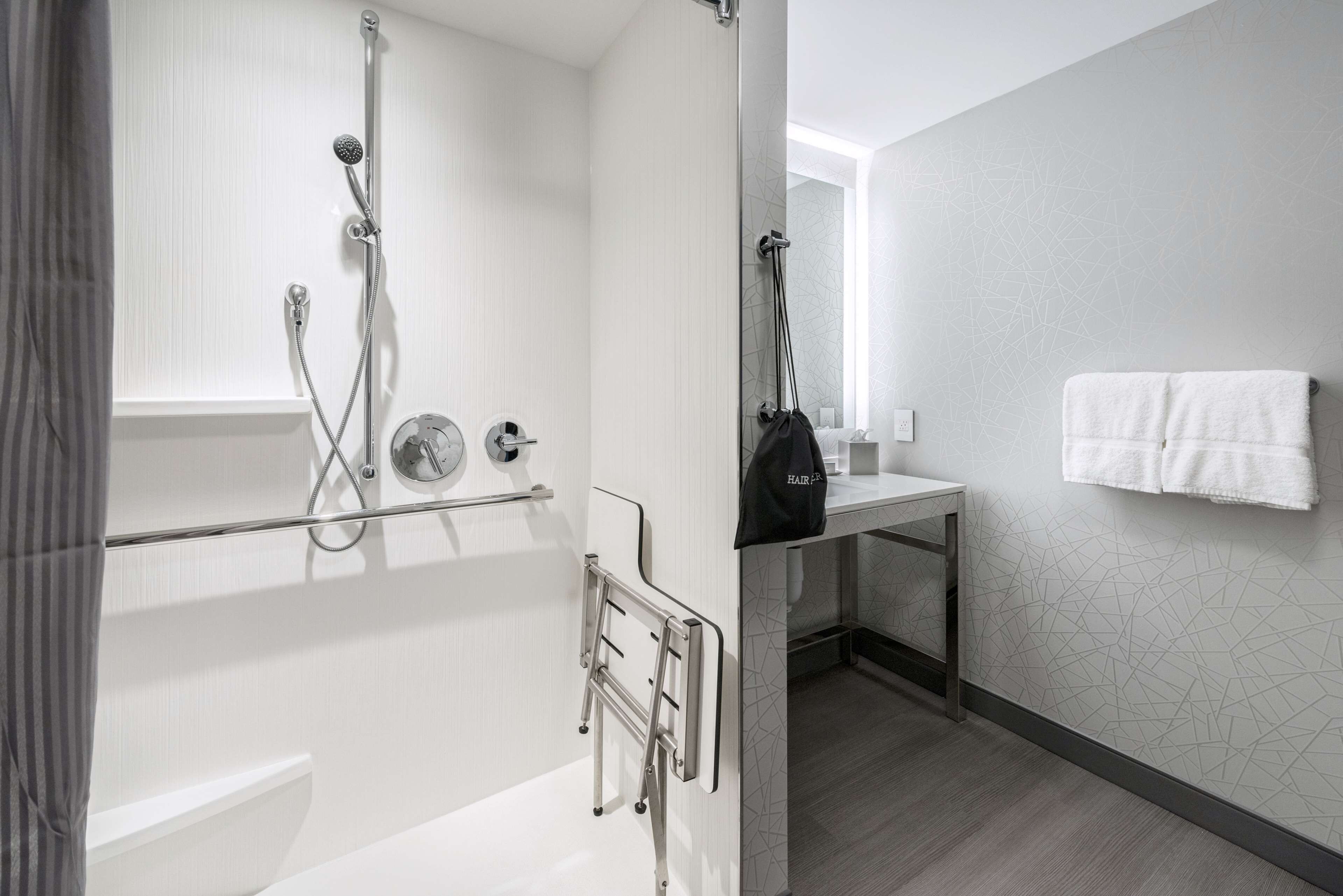 A modern bathroom with a shower, toilet, and sink.