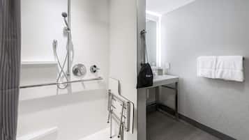 A modern bathroom with a shower, toilet, and sink.