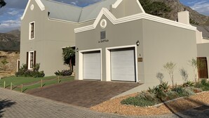 A two-story building with a grey facade, two garage doors, and a sign reading "La Grattitude." - La Gratitude Guest House (Franschhoek)