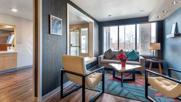 A modern living room with a sofa, armchairs, and a coffee table. There is a large window providing natural light and a view of the outside. - Extended Stay America Select Suites - Pittsburgh - Cranberry (Cranberry Township)