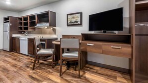 A compact kitchen with a dining area, a built-in TV, and a refrigerator. - Extended Stay America Select Suites - Pittsburgh - Cranberry (Cranberry Township)