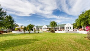 A modern building with a green roof, surrounded by a well-maintained lawn and trees. - Lady Loch Country House (Wellington)
