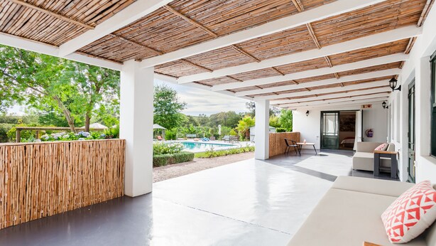 A covered outdoor area with a pool, seating, and a view of the surrounding greenery. - Lady Loch Country House (Wellington)