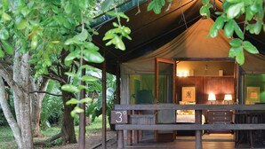 A tented accommodation with a wooden deck, a visible room with a bed and a desk, and a number '3' sign. - Falaza Game Lodge (Hluhluwe)
