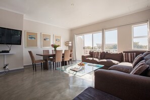 Apartamento (2 Bedrooms) | Zona de estar | Televisión de pantalla plana de 50 pulgadas con canales por satélite