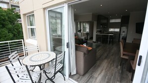 Un apartamento moderno con balcón, comedor y cocina.
