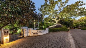 L’entrée d’un hôtel de charme, avec une allée pavée, un grand arbre et une enseigne indiquant « Sheppard Boutique ».