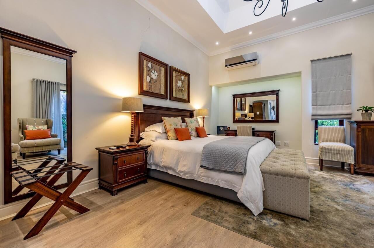 A modern bedroom with a large bed, bedside tables, a mirror, and a view of the outdoors.