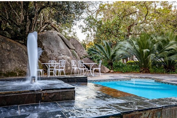 Una piscina al aire libre, tumbonas