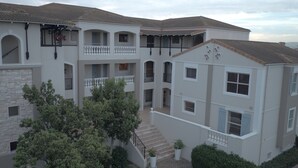 A multi-story residential building with balconies, a staircase, and a courtyard. - Bougain Villas Apartments (Cape Town)