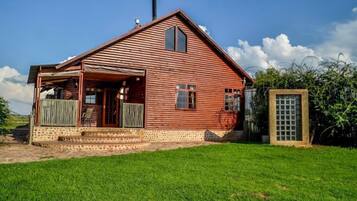 Cozy cabin surrounded by a serene lawn, offering a simple, natural retreat.