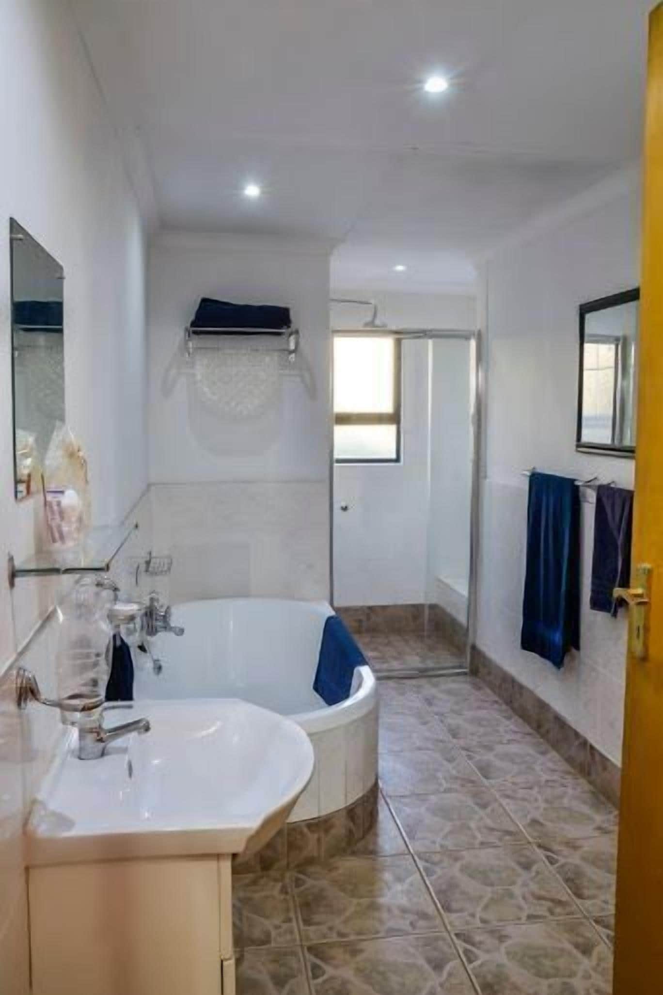 Een moderne badkamer met een vrijstaand bad, een wastafel en een spiegel.