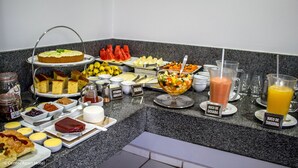 Un bufé de desayuno con diversas opciones de comida y bebidas.