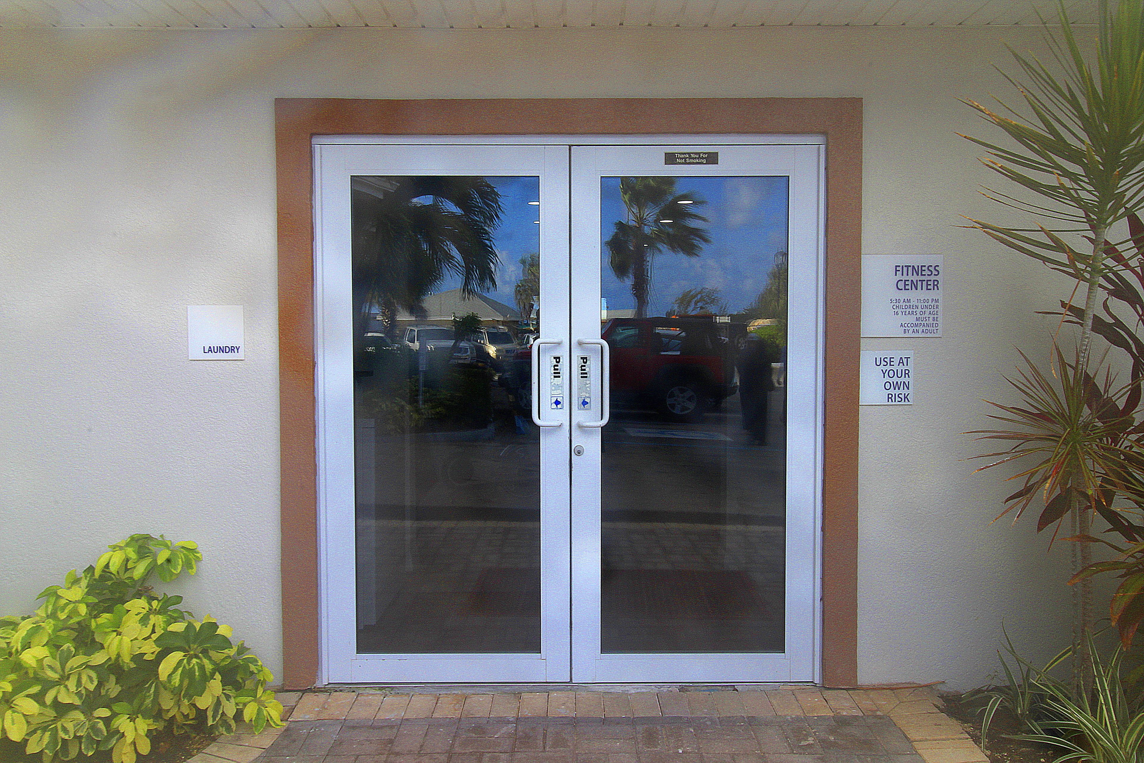 A double door entrance with a sign indicating a fitness center.