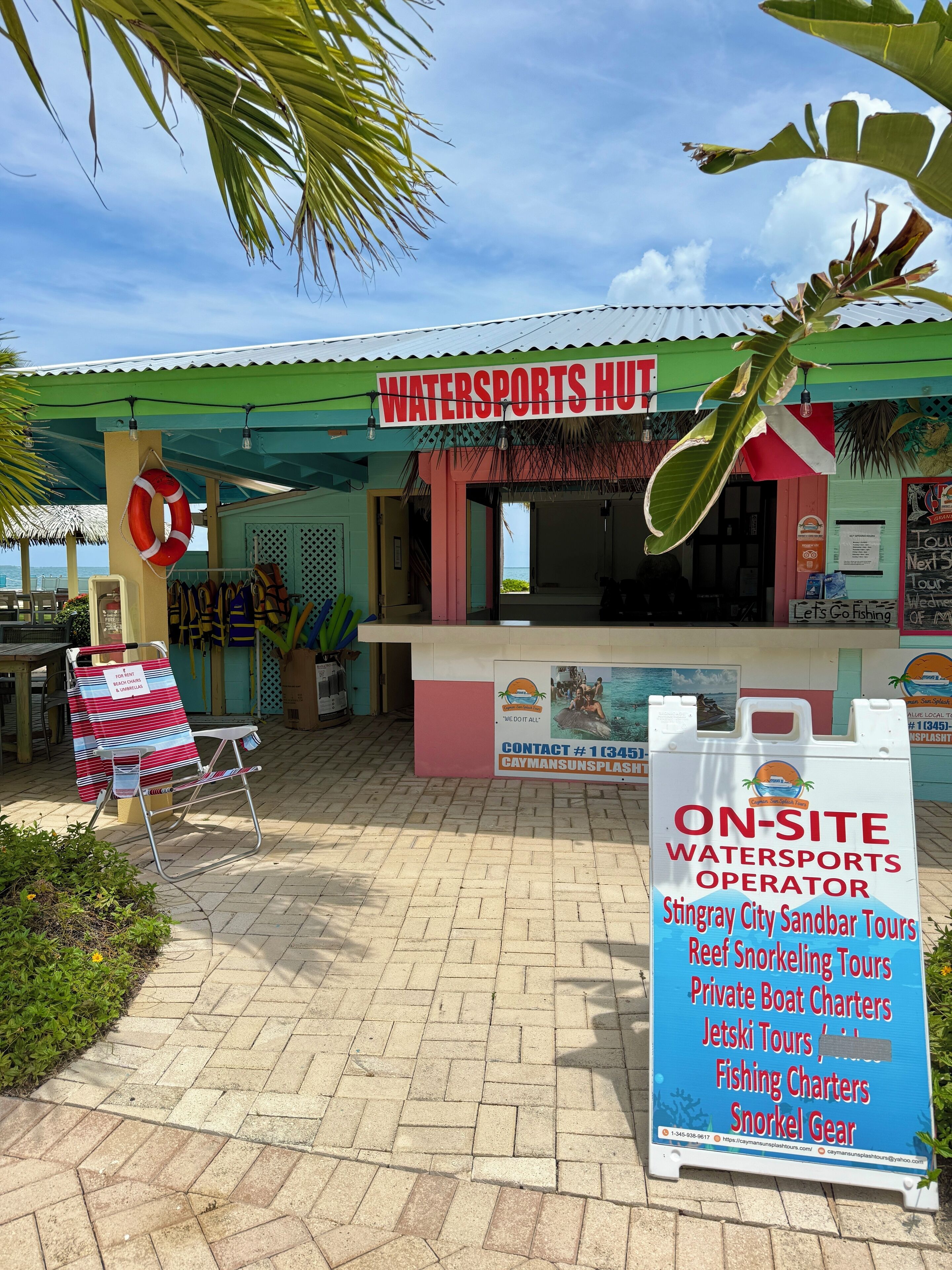 Un chalet dédié aux sports nautiques, avec une enseigne indiquant les services proposés sur place, notamment des excursions et des locations de bateaux.