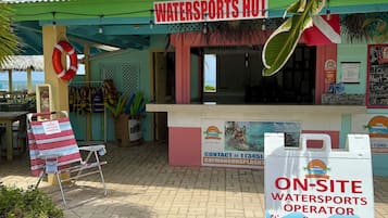 Un chalet dédié aux sports nautiques, avec une enseigne indiquant les services proposés sur place, notamment des excursions et des locations de bateaux.