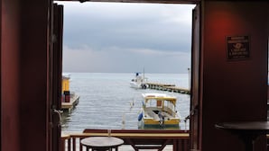 A view from inside a building looking out to a body of water with boats, a pier, and a hurricane evacuation plan sign. - Spindrift Hotel (San Pedro)