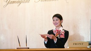 Een hotel receptie met een bord waarop 'Yamagata Kokusan Hotel' staat.