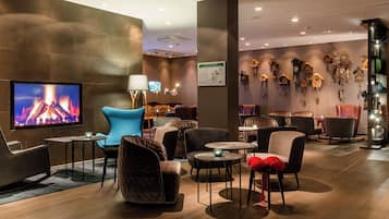 Relax in comfort with a large flat-screen TV, cozy seating areas, and decorative clocks.