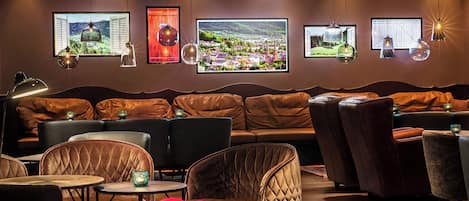 Un espacio lounge moderno con sofás de cuero, mesas redondas y sillas.