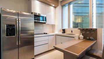 A modern kitchen with stainless steel appliances, a built-in microwave, and a large window providing natural light.