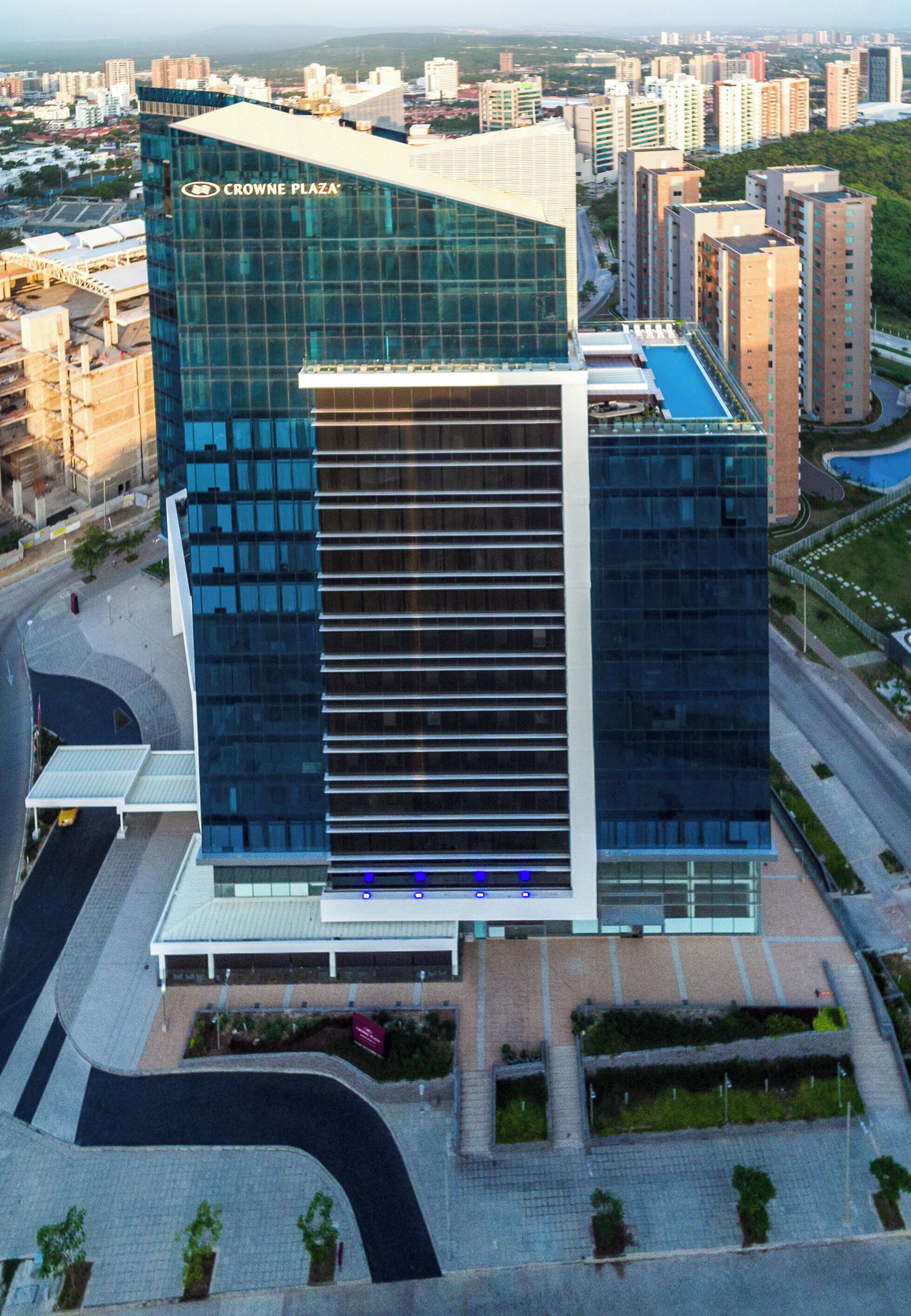 A modern building with a glass facade and a sign reading 'CROWNE PLAZA'.