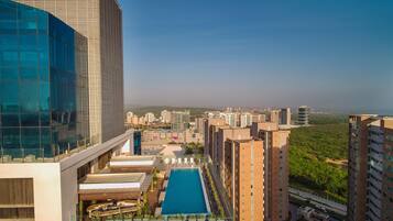 A high-rise building with a rooftop pool and adjacent residential buildings.