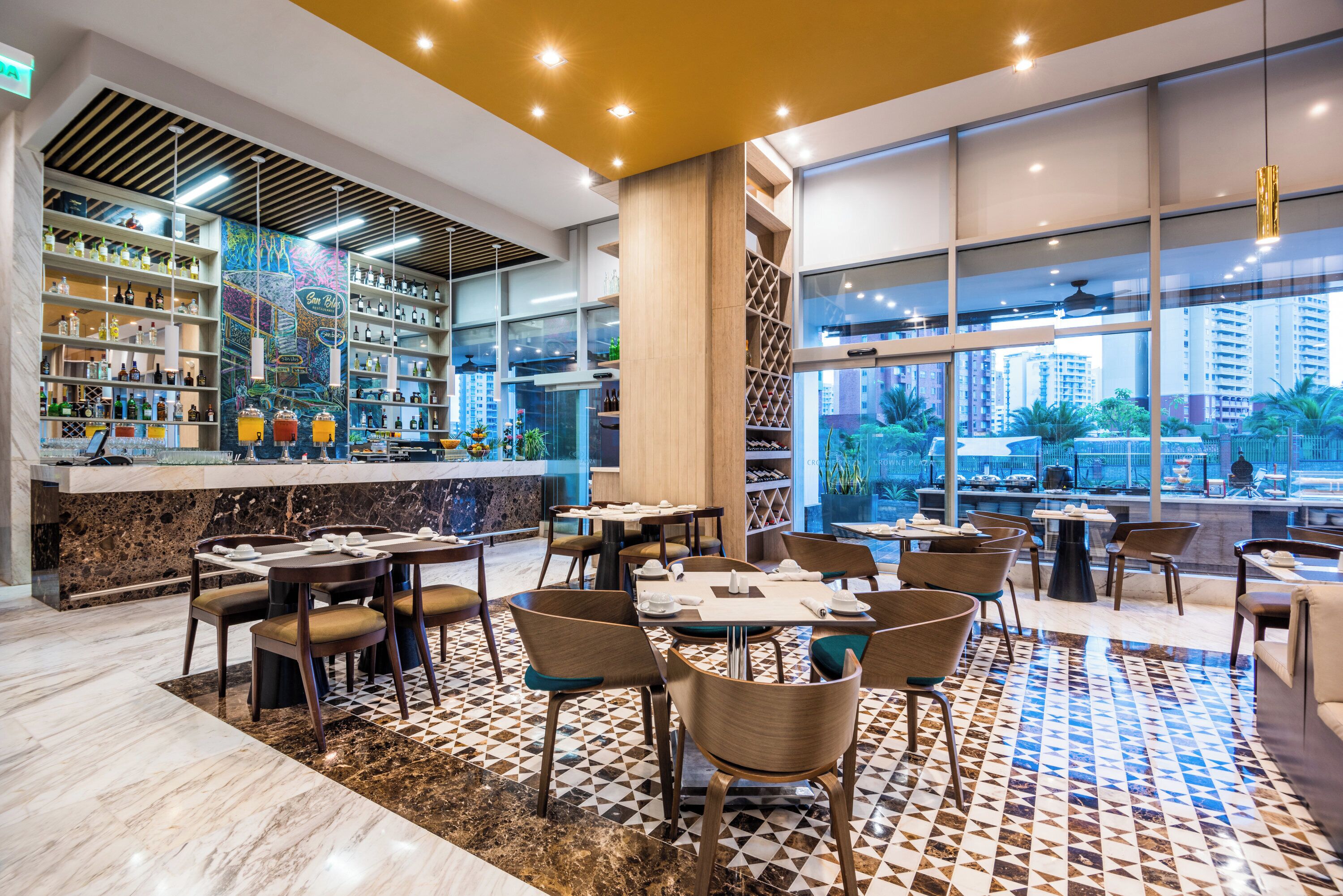 A modern restaurant with a bar area, dining tables, and chairs.