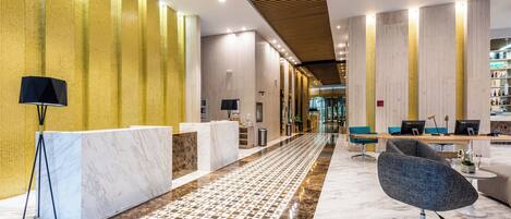 Um hall moderno com balcão de recepção, área de estar e piso estampado.
