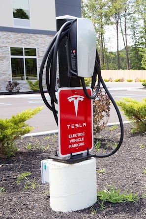 A Tesla electric vehicle charging station with a red sign indicating it is for Tesla vehicles. - Hampton Inn Atlantic City/Absecon (Absecon)