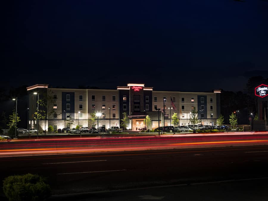 A Hampton Inn hotel with a modern facade, multiple floors, and a well-lit entrance.