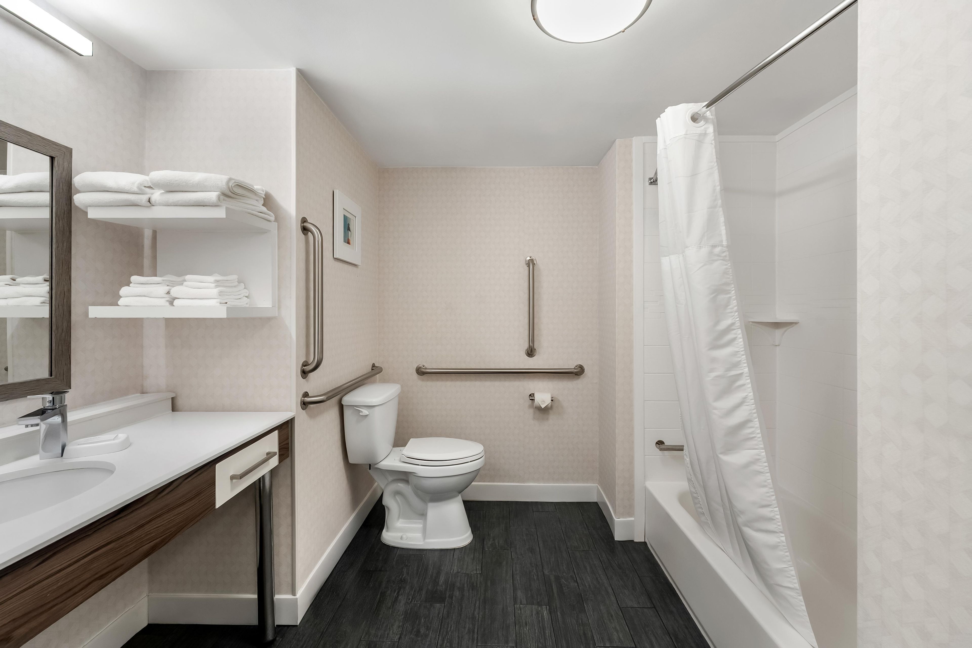 Un baño moderno con inodoro, lavamanos y ducha.