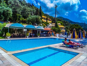 Piscine extérieure, parasols de plage, chaises longues