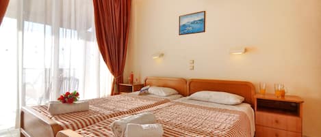A hotel room with two beds, a nightstand with a lamp, a picture on the wall, and an air conditioning unit.