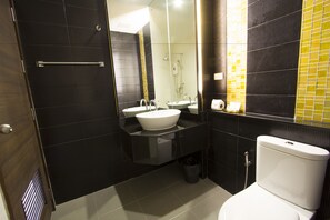 A modern bathroom with a glass shower enclosure, a white sink, and a toilet. - Siva Royal Hotel (Phatthalung)